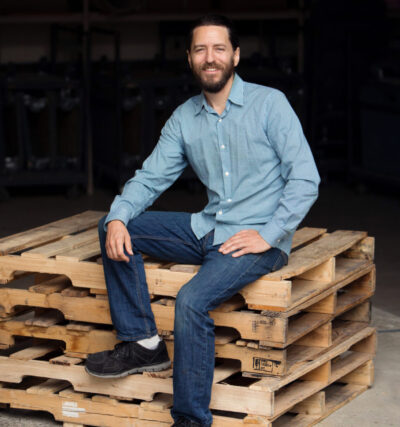 DLO office moving experts - Scott Perry sitting on wooden palette