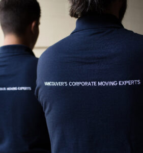 Two people's backs wearing shirts that read "Vancouver's corporate moving experts"
