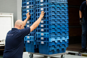 man pushing moving boxes into moving truck